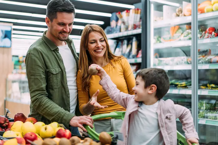 Family selecting produce in grocery store