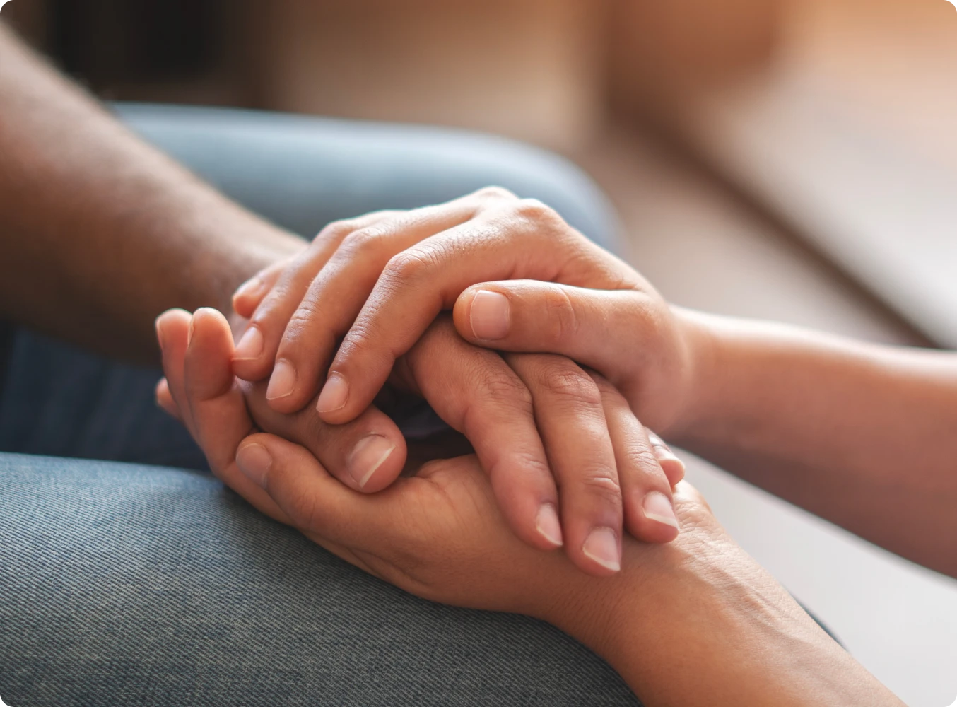 Hands gently holding another in support.
